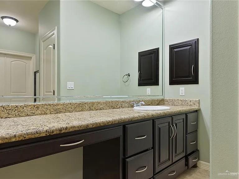 2709 Cardinal Avenue McAllen, TX 78504 - Photo 14 of 19 a bathroom with a granite countertop sink and a large mirror