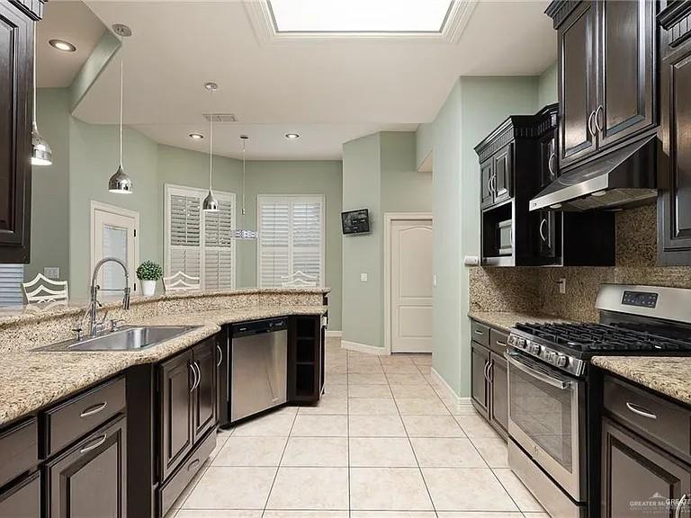 2709 Cardinal Avenue McAllen, TX 78504 - Photo 7 of 19 a kitchen with stainless steel appliances granite countertop a sink and a stove