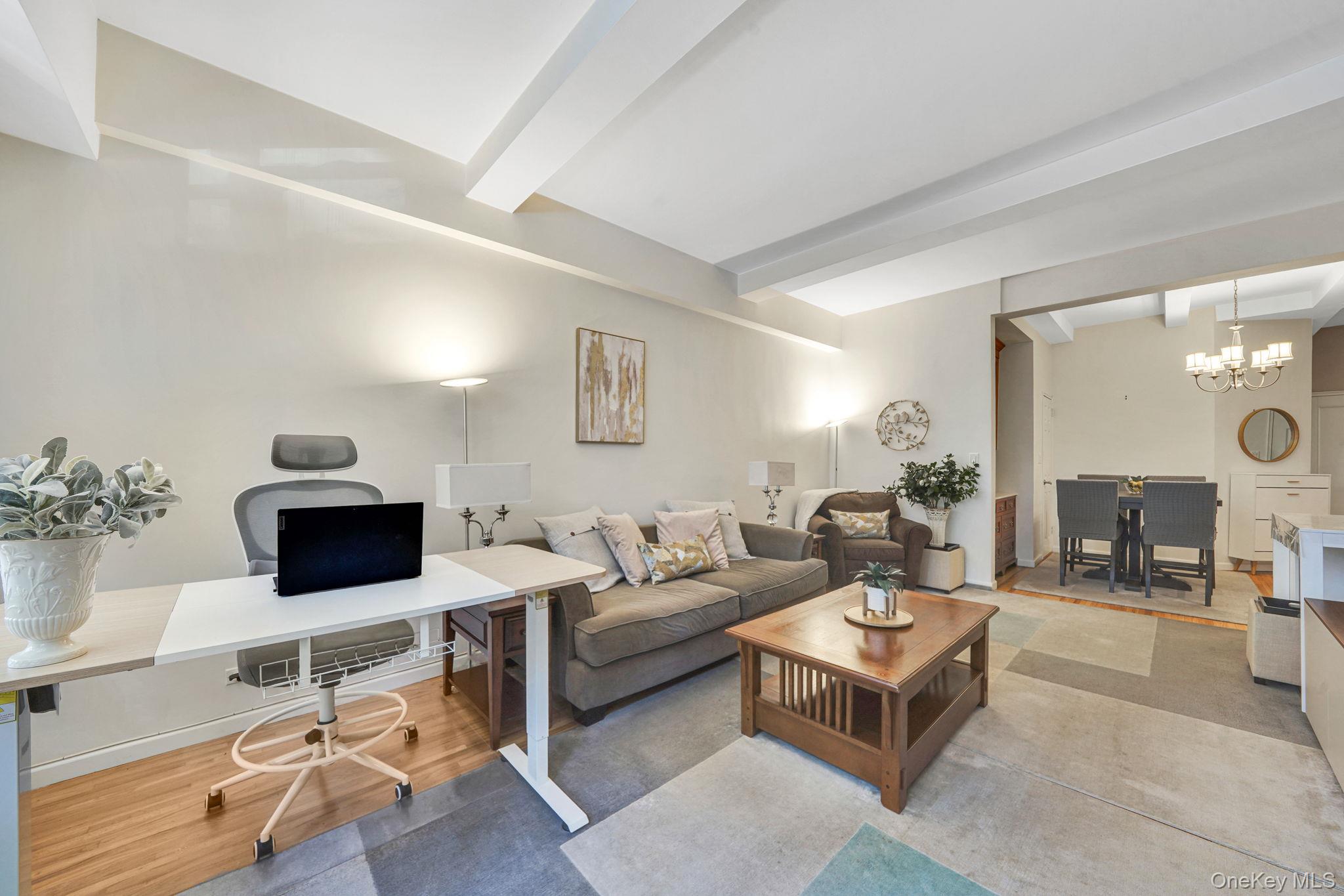 640 West 231st Street, Unit 1F Bronx, NY 10463 - Photo 5 of 17 a living room with furniture a flat screen tv and a table