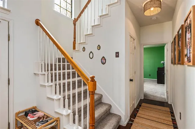 a view of staircase with lots of frames on wall and wooden floor