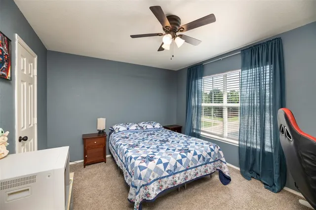 a bedroom with a bed and a large window