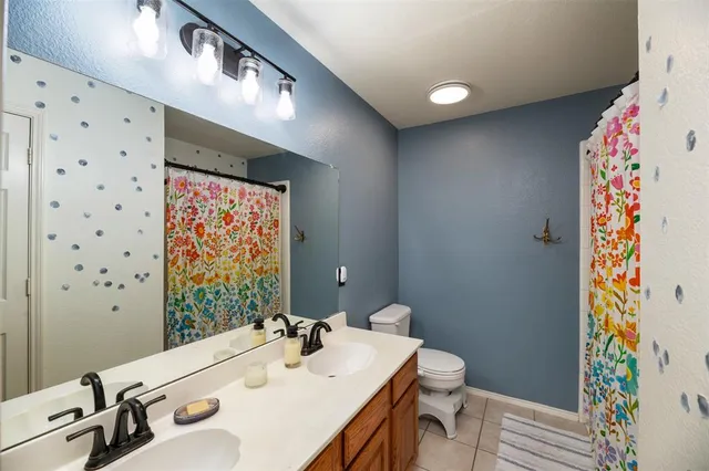 a bathroom with a sink mirror vanity and toilet