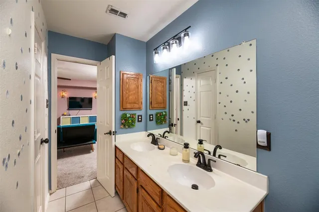 a bathroom with a double vanity sink mirror and shower
