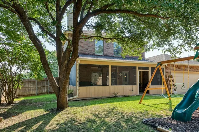 a view of a house with backyard and a tree