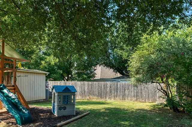 a view of a backyard with small cabin and wooden fence