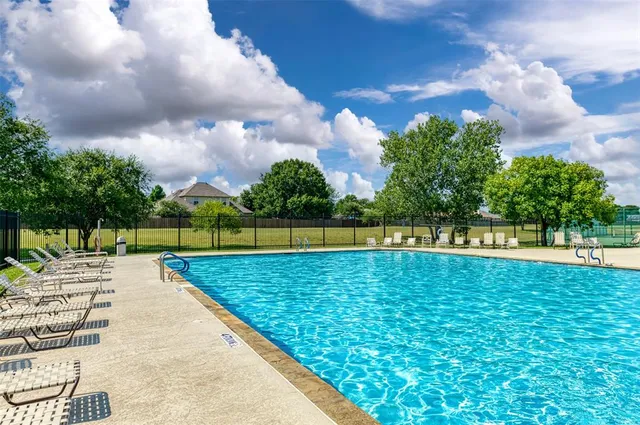 a view of a swimming pool and a yard in the background