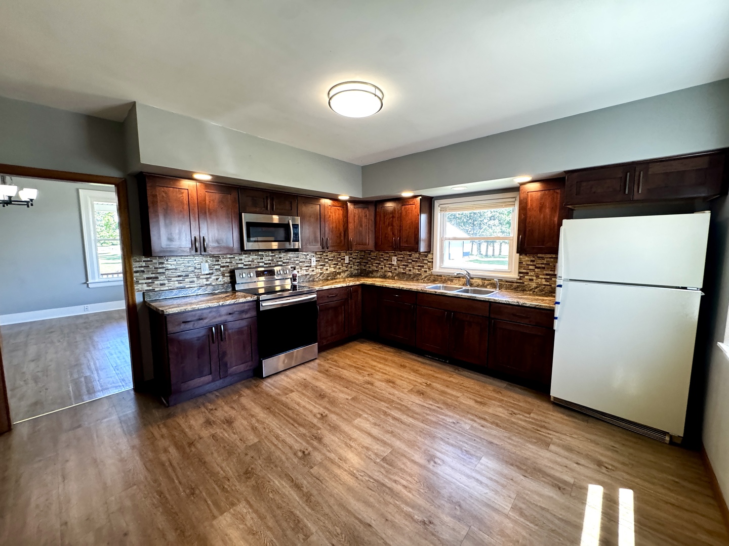 16606 West Backbone Road Princeton, IL 61356 - Photo 8 of 40 a kitchen with stainless steel appliances granite countertop a refrigerator a sink dishwasher a stove with wooden floors and cabinets