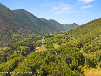 a view of a lush green hillside and mountains