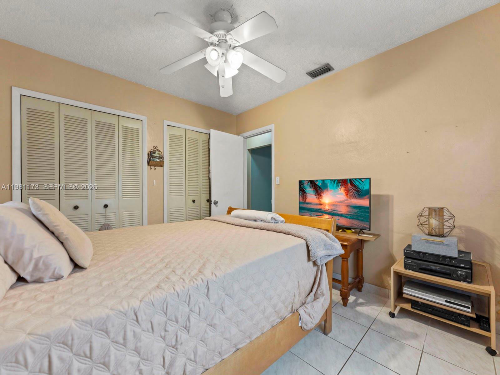 27 East 12th Street Hialeah, FL 33010 - Photo 12 of 24 a bedroom with a bed and a chandelier