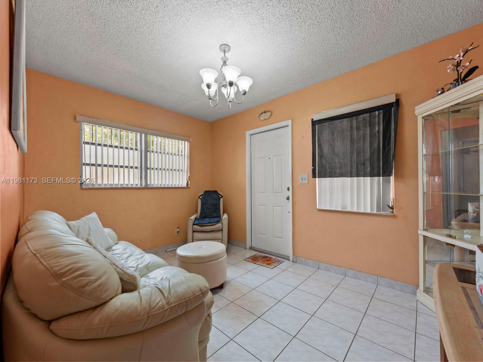 27 East 12th Street Hialeah, FL 33010 - Photo 9 of 24 a living room with furniture and a chandelier