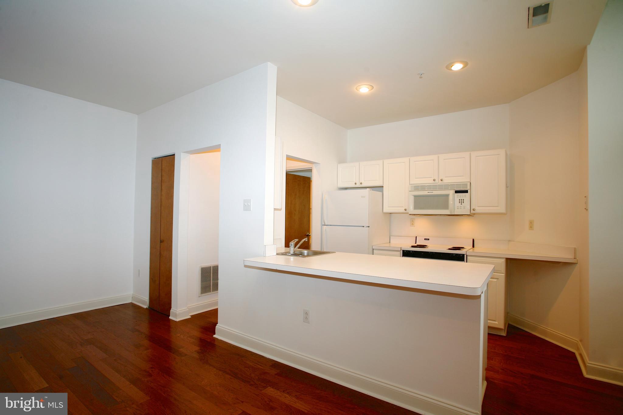 1600-1 Walnut Street, Unit 402 Philadelphia, PA 19103 - Photo 7 of 14 a kitchen with stainless steel appliances a sink a stove a refrigerator and cabinets