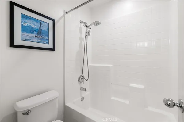 a white bath tub sitting next to a white toilet and a shower