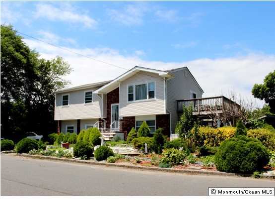 1137 Leonard Road Point Pleasant, NJ 08742 - Photo 1 of 25 a front view of a house with a yard and potted plants