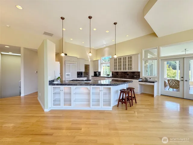 a large kitchen with kitchen island a living room a refrigerator a table and chairs