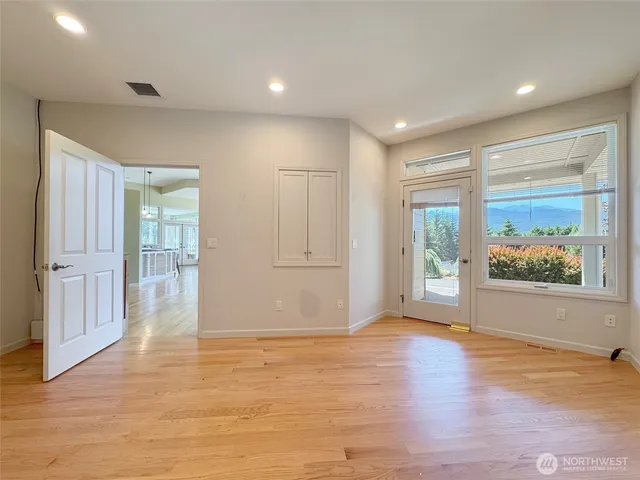 an empty room with wooden floor and windows