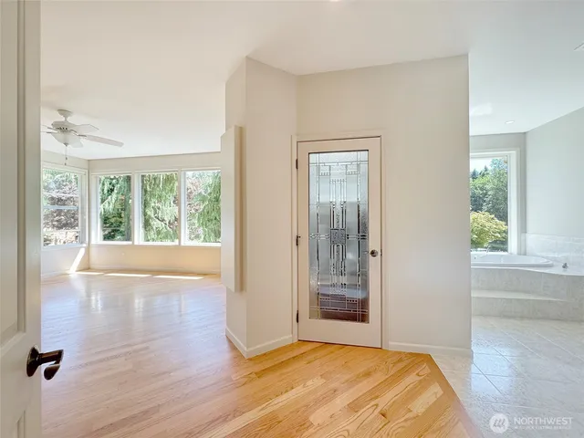 a view of empty room with wooden floor and fan