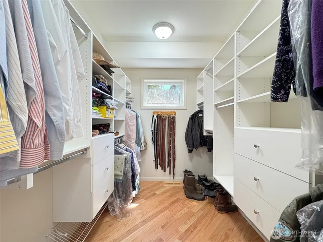 a view of walk in closet with clothes and shoes