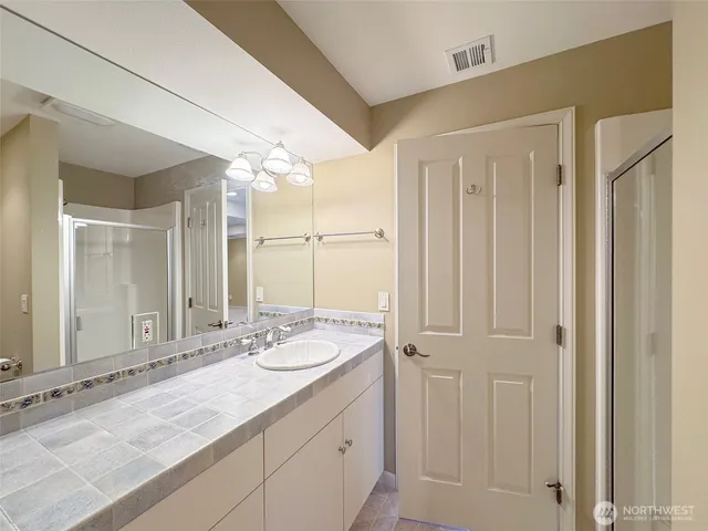 a bathroom with a granite countertop sink and a mirror