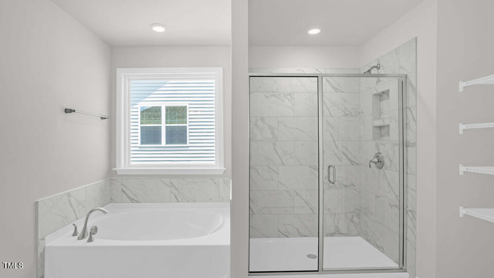 176 Red Jasper Way Clayton, NC 27520 - Photo 18 of 35 a bathroom with a shower and a bathtub