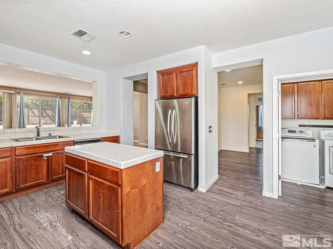 404 Sysonby Court Reno, NV 89521 - Photo 12 of 25 a kitchen with stainless steel appliances granite countertop a stove top oven and refrigerator