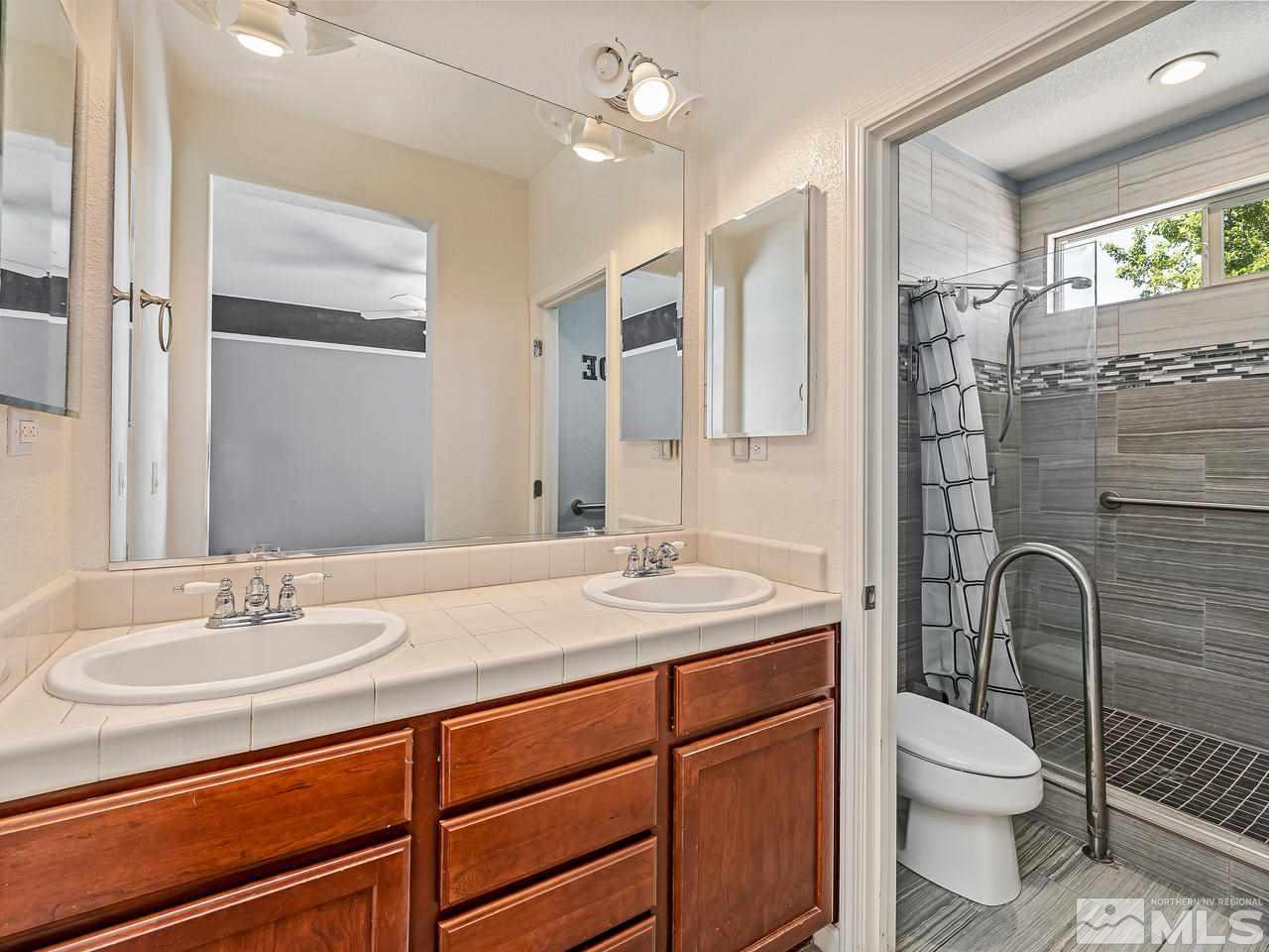 404 Sysonby Court Reno, NV 89521 - Photo 14 of 25 a bathroom with a sink a toilet a mirror and shower