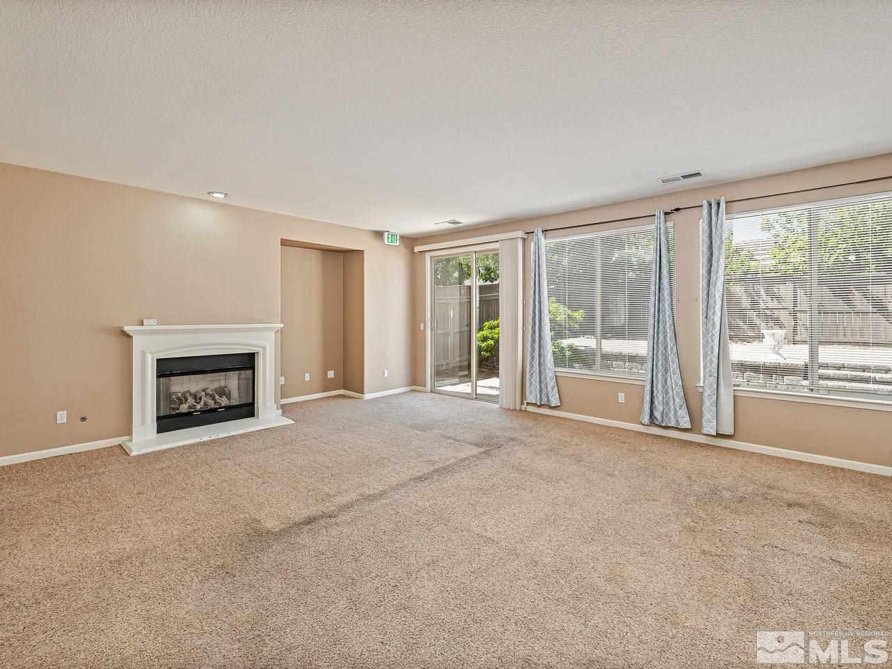 404 Sysonby Court Reno, NV 89521 - Photo 7 of 25 a view of an empty room with a fireplace and a window