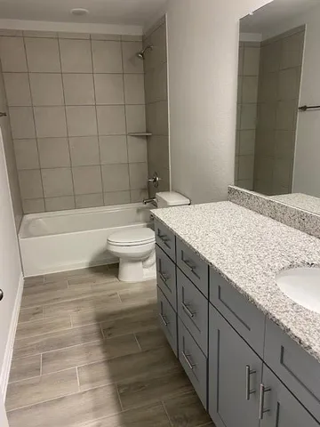 a bathroom with a granite countertop sink toilet and shower
