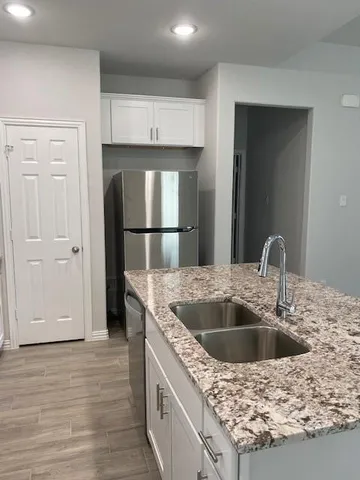 a kitchen with kitchen island a sink a stove and refrigerator