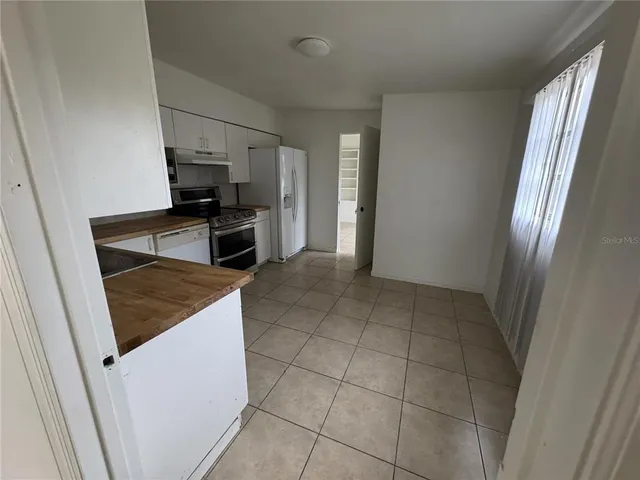 a kitchen with stainless steel appliances a refrigerator and a stove top oven