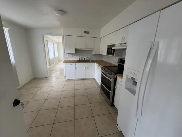 a kitchen with stainless steel appliances a refrigerator sink and microwave