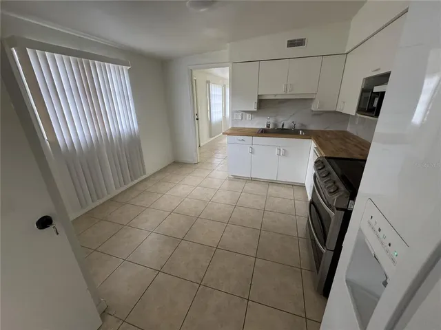 a kitchen with a sink a stove a washer dryer and granite countertops