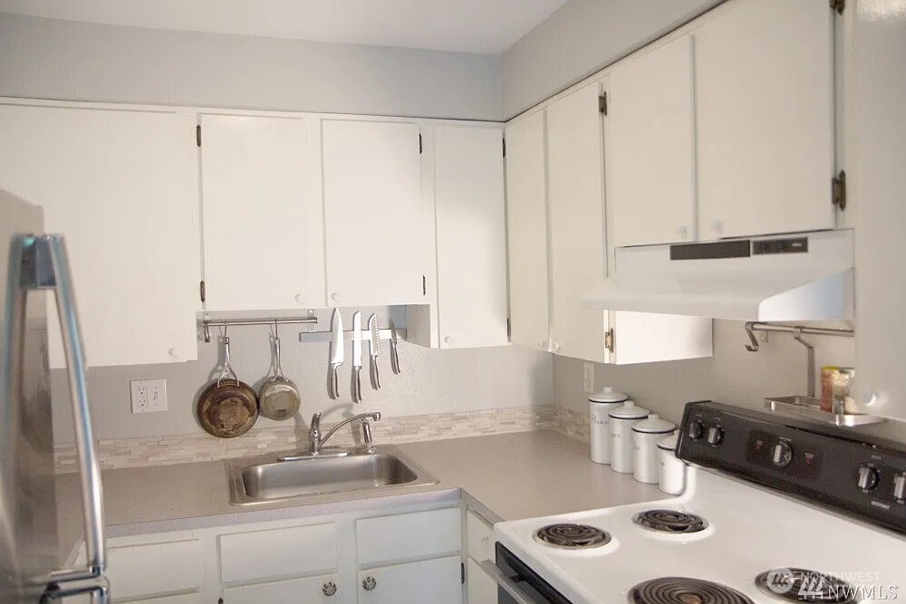230 Southwest Clark Street, Unit C302 Issaquah, WA 98027 - Photo 5 of 8 a kitchen with a sink and a stove with white cabinet