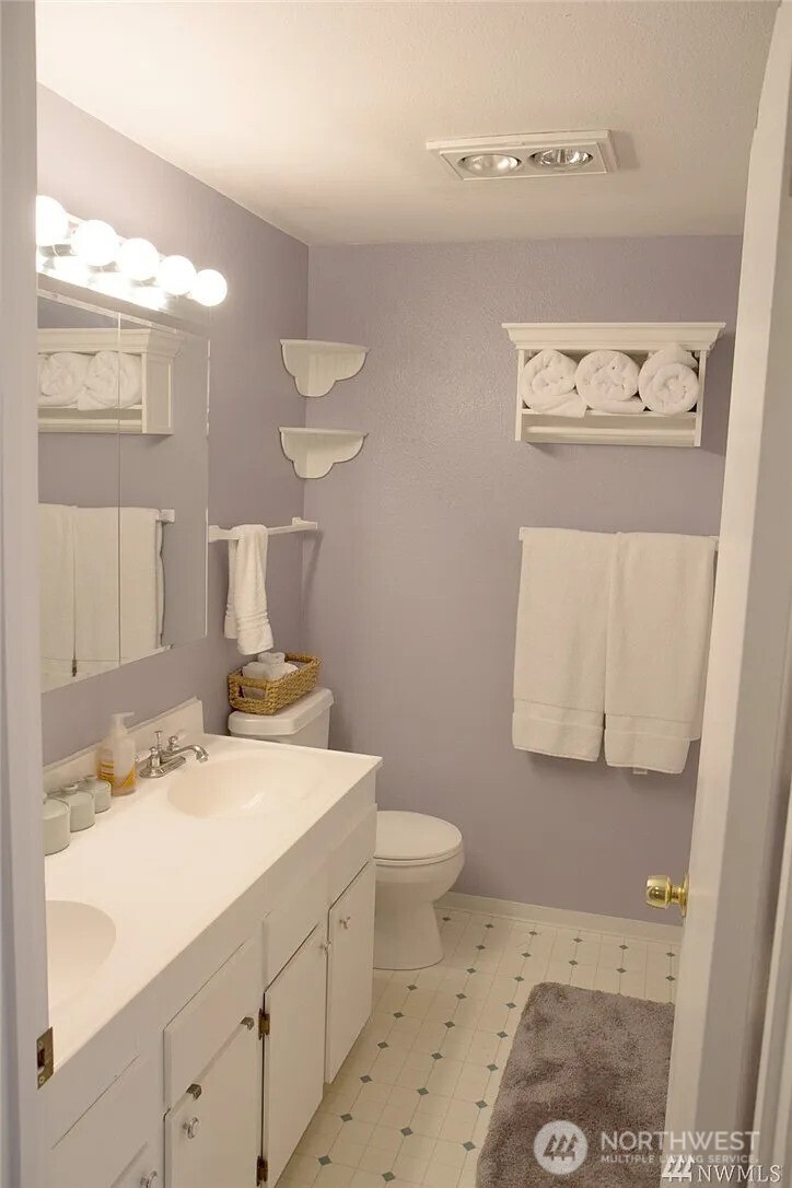 230 Southwest Clark Street, Unit C302 Issaquah, WA 98027 - Photo 7 of 8 a bathroom with a sink a toilet and mirror