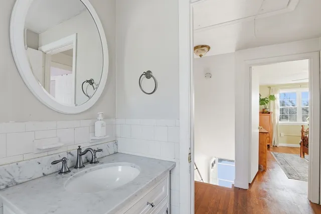 a bathroom with a granite countertop sink a mirror and a shower