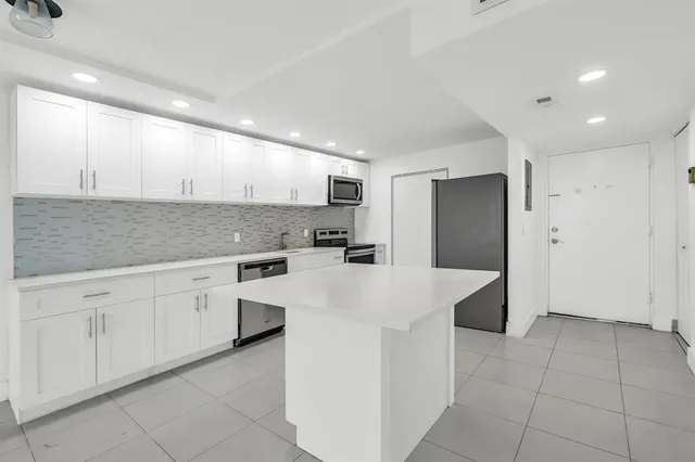 a kitchen with stainless steel appliances a refrigerator sink and cabinets