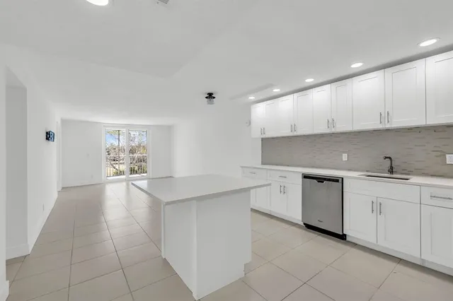 a kitchen with granite countertop a sink and white cabinets
