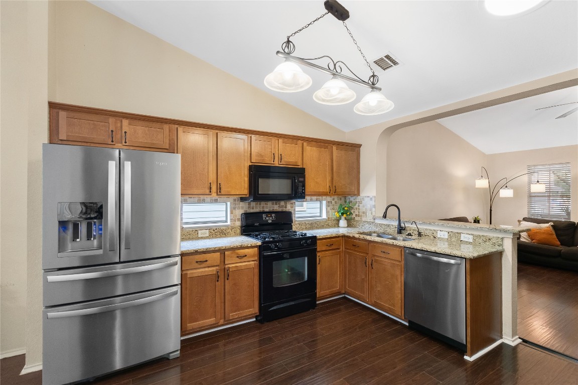 317 Strawn Kyle, TX 78640 - Photo 11 of 38 a kitchen with stainless steel appliances granite countertop a refrigerator a sink dishwasher a stove and a refrigerator