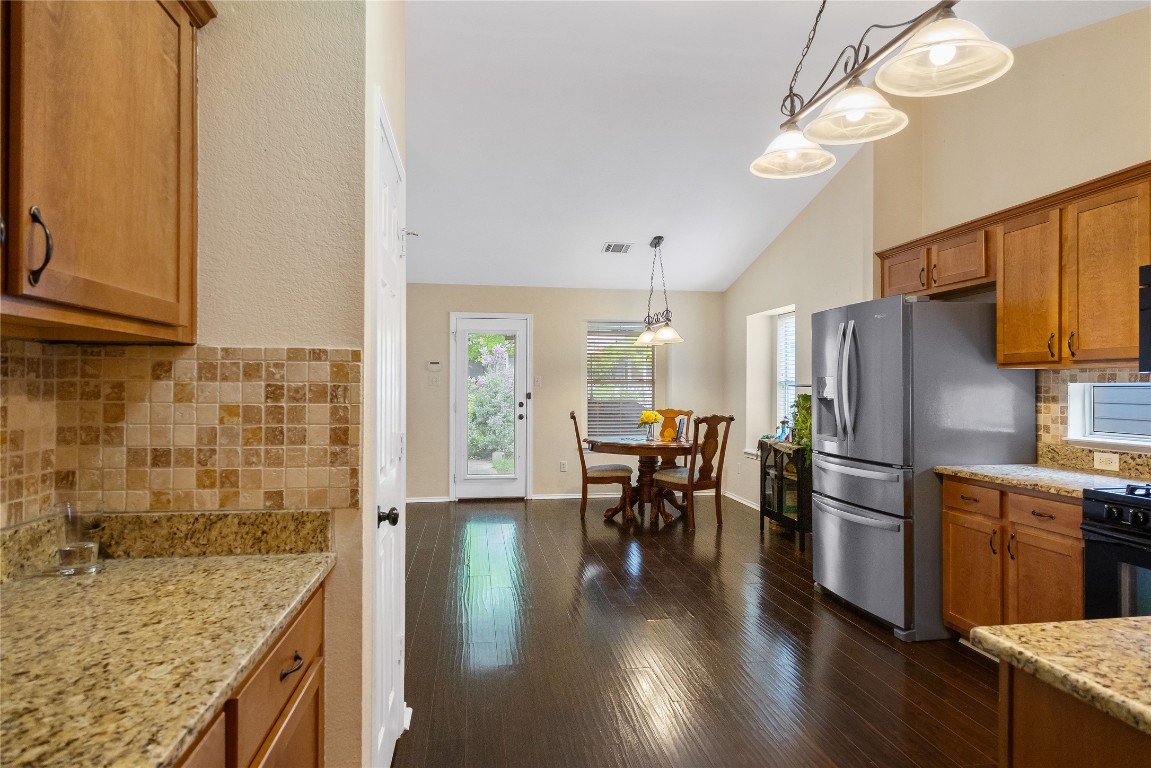 317 Strawn Kyle, TX 78640 - Photo 13 of 38 a kitchen with granite countertop a counter space dining table and stainless steel appliances