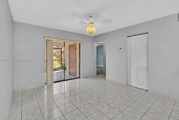 an empty room with a ceiling fan and window