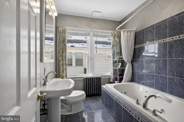 a bathroom with a tub sink and mirror