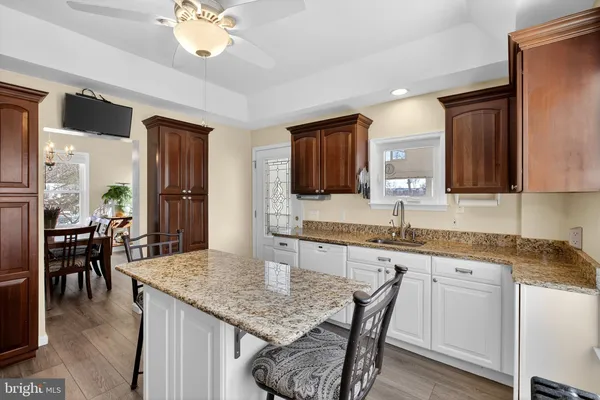 a kitchen with granite countertop kitchen island a sink stove and dining table
