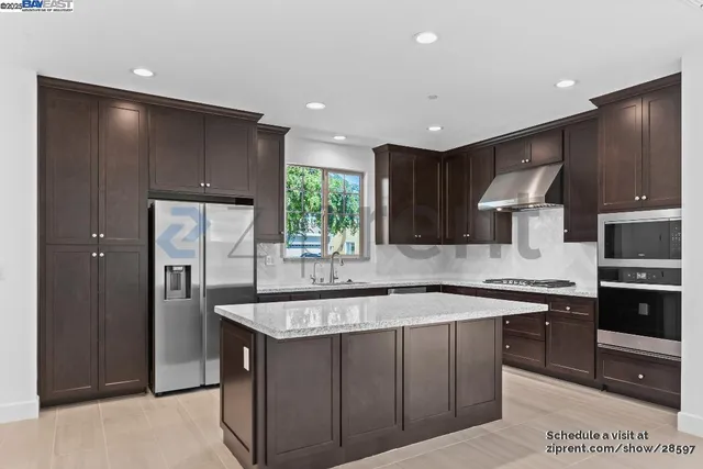 a kitchen with stainless steel appliances granite countertop a sink stove and refrigerator