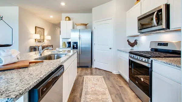 a kitchen with stainless steel appliances granite countertop a sink a stove and microwave