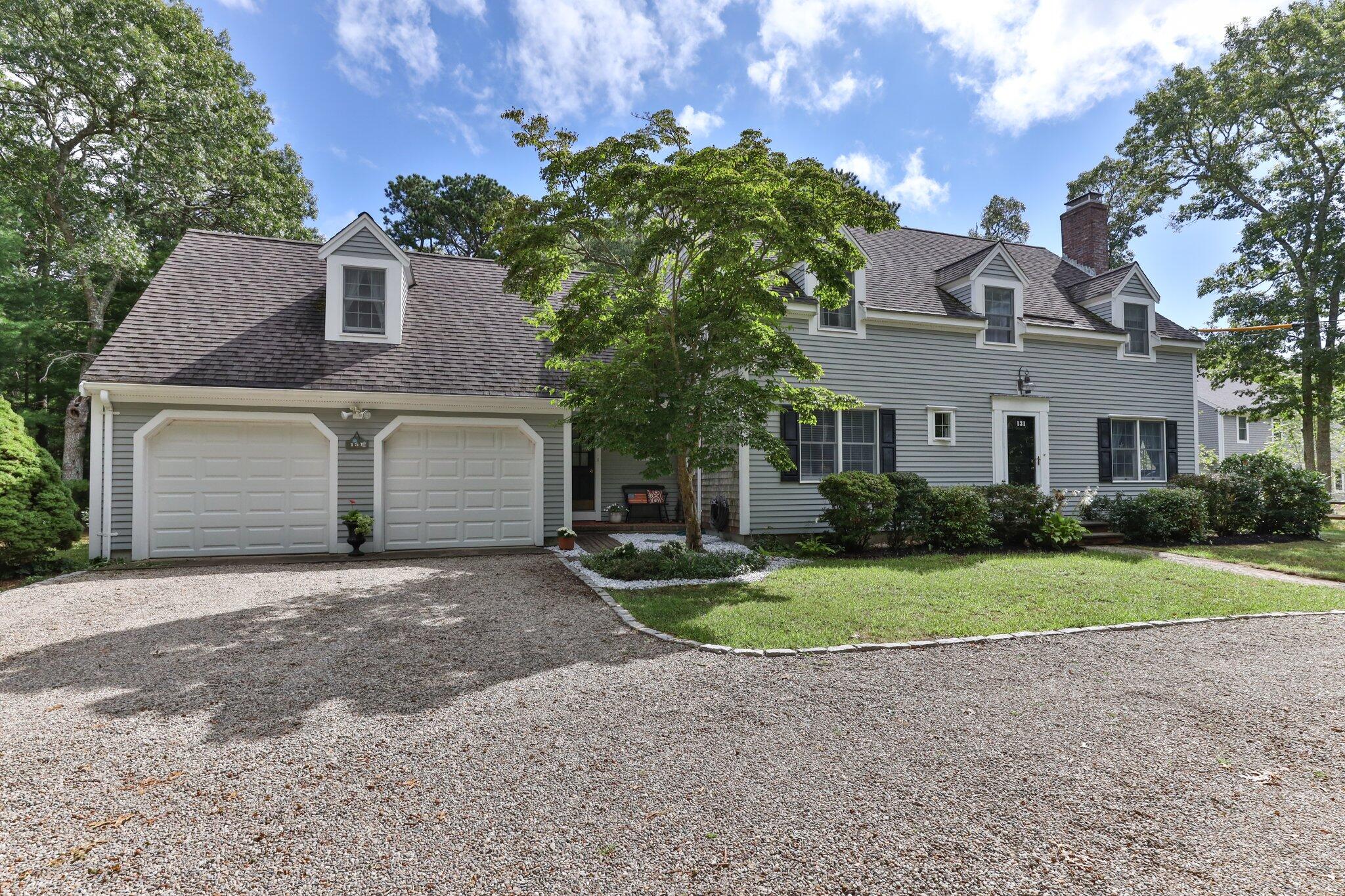 131 Clamshell Cove Road Cotuit, MA 02635 - Photo 5 of 67 a front view of a house with a yard and garage