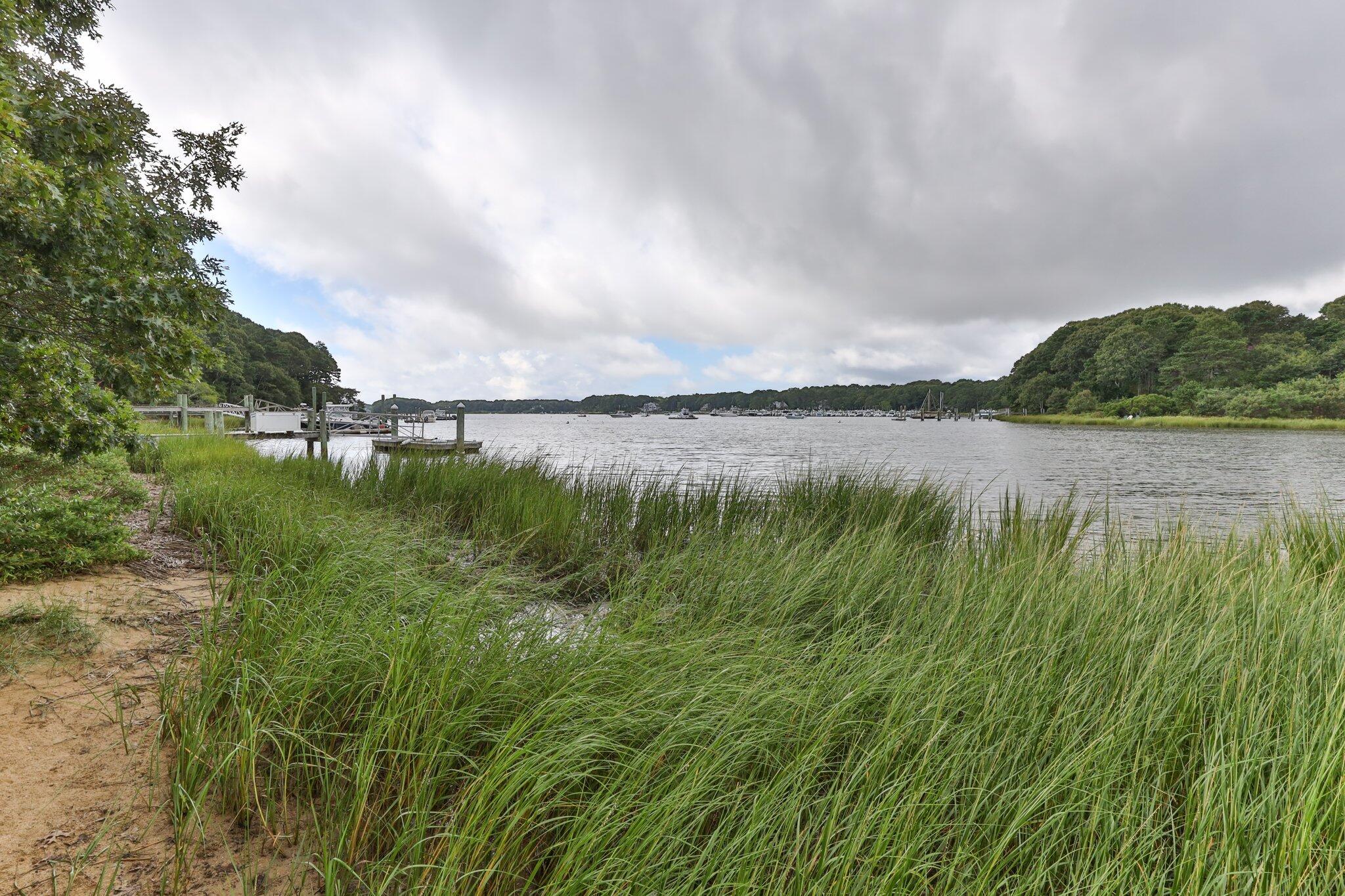 131 Clamshell Cove Road Cotuit, MA 02635 - Photo 61 of 67 a view of a lake with houses in the back
