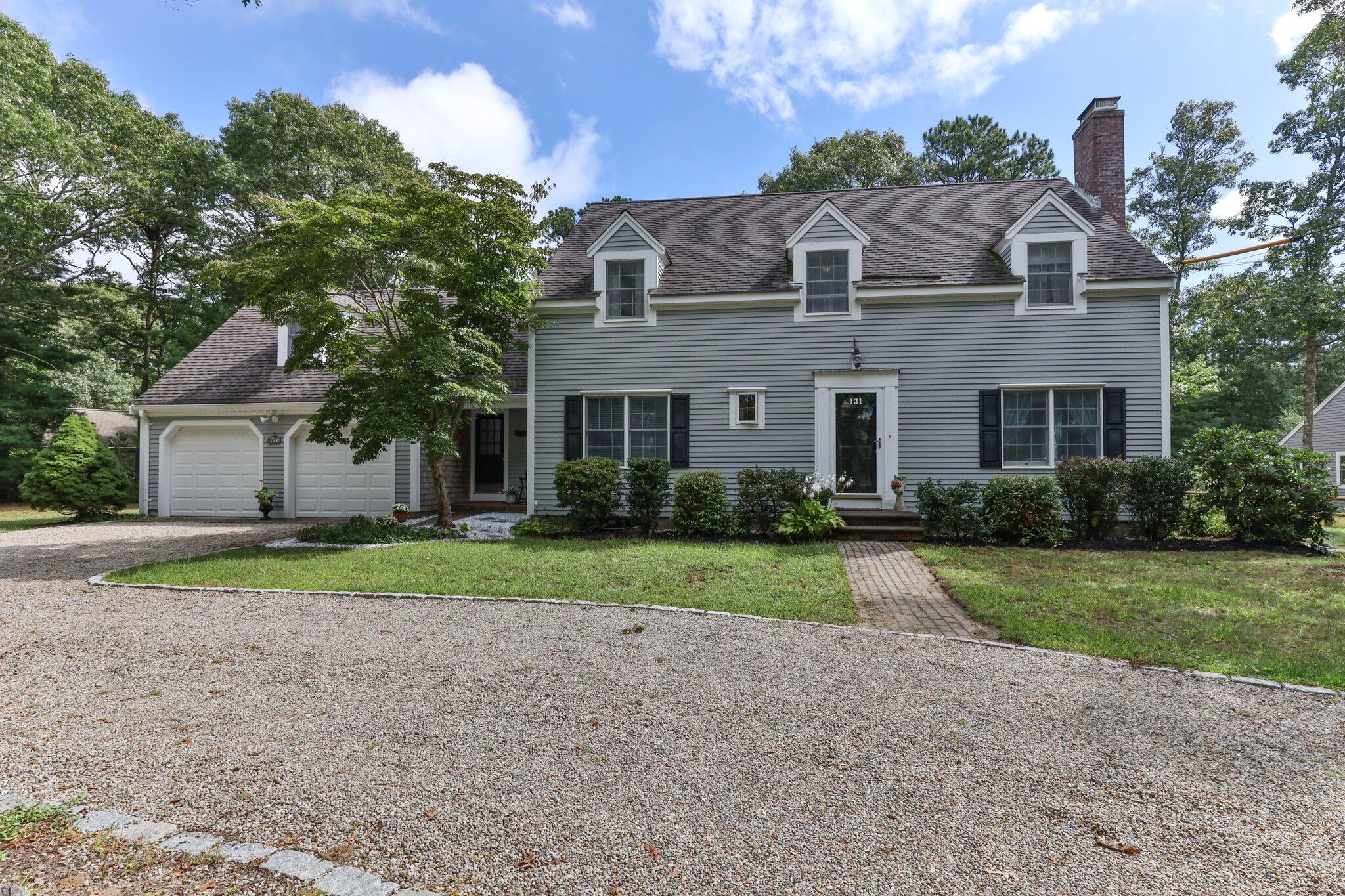 131 Clamshell Cove Road Cotuit, MA 02635 - Photo 7 of 67 a front view of a house with a yard and garage