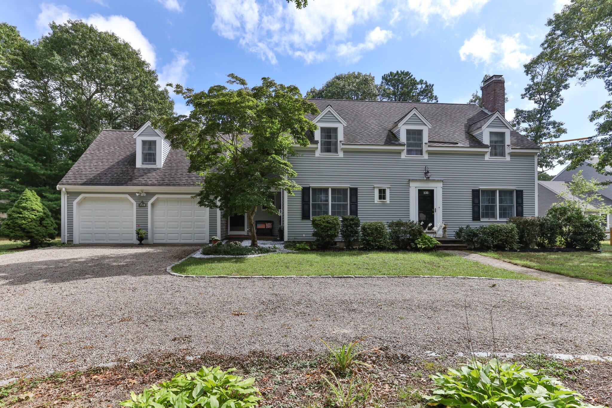 131 Clamshell Cove Road Cotuit, MA 02635 - Photo 8 of 67 a front view of a house with a yard and garage