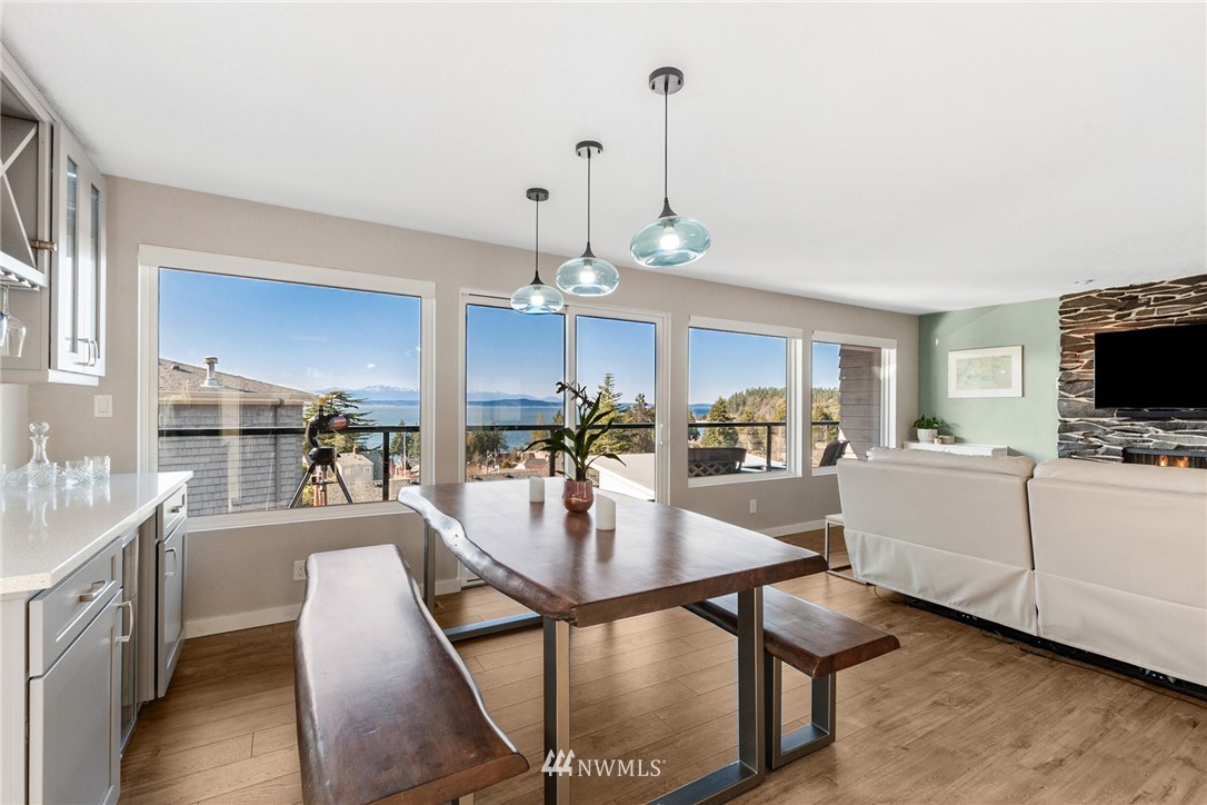 9337 45th Avenue Southwest Seattle, WA 98136 - Photo 12 of 30 a view of a dining room and livingroom with furniture wooden floor a chandelier