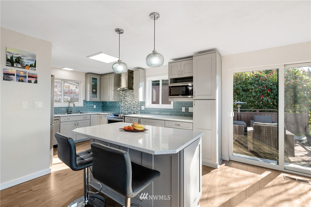 9337 45th Avenue Southwest Seattle, WA 98136 - Photo 10 of 30 a kitchen with a table a sink and cabinets