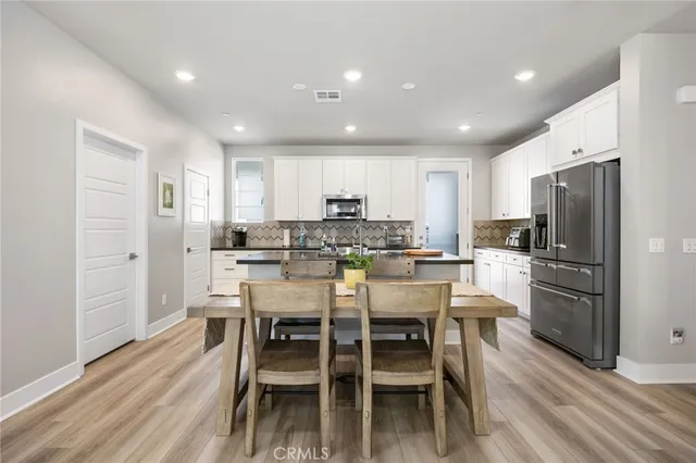 a kitchen with granite countertop a sink stainless steel appliances and white cabinets